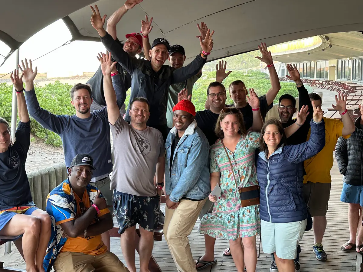 The Codeo team waving at a beachfront venue